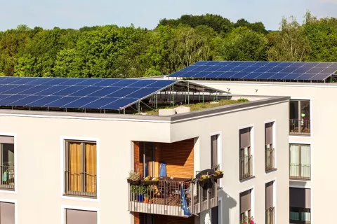 Ein Mehrfamilienhaus mit Solaranlage über das komplette Dach.